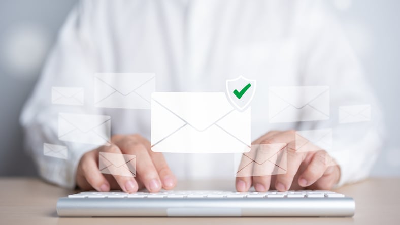 Man typing on his keyboard completing legacy email archiving solutions